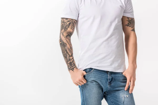 Vue recadrée de jeune homme tatoué en jeans posant isolé sur blanc — Photo de stock