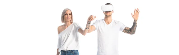 Young tattooed man in vr headset near smiling girlfriend isolated on white, panoramic shot — Stock Photo