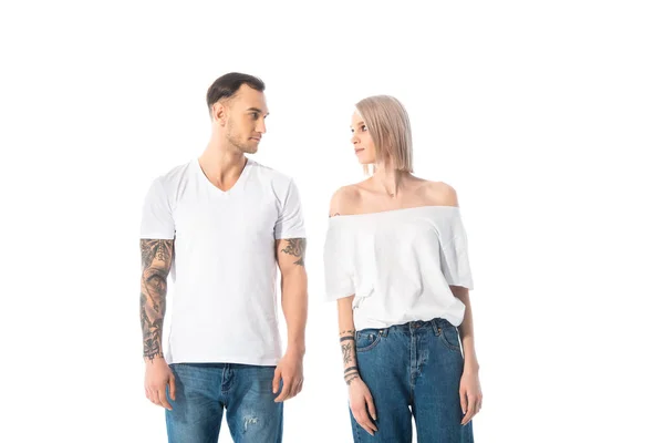 Giovane coppia tatuata guardando l'un l'altro isolato su bianco — Foto stock