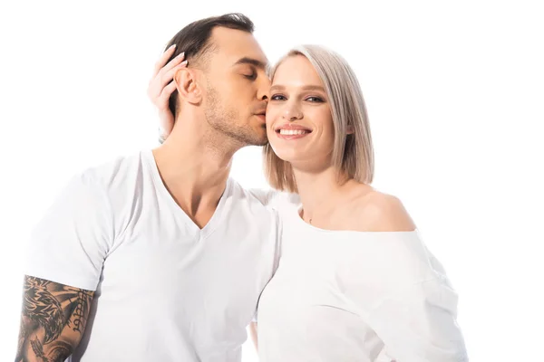 Feliz jovem tatuado casal abraçando e beijando isolado no branco — Fotografia de Stock