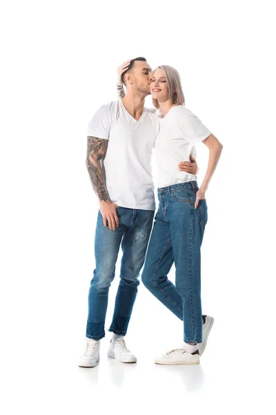 Jeune couple tatoué étreignant et embrassant isolé sur blanc — Photo de stock