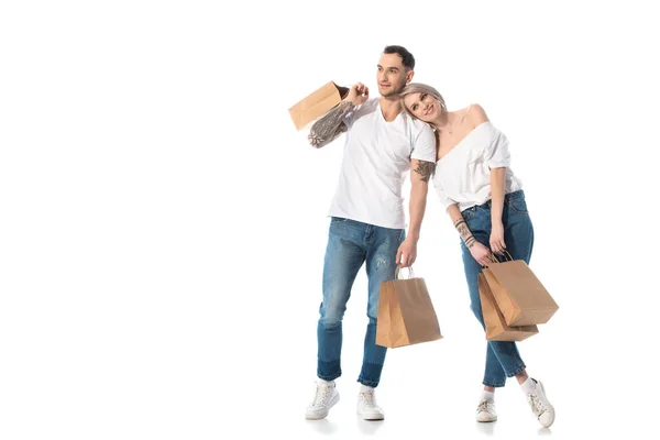 Sourire jeune couple tatoué avec des sacs à provisions isolés sur blanc — Photo de stock