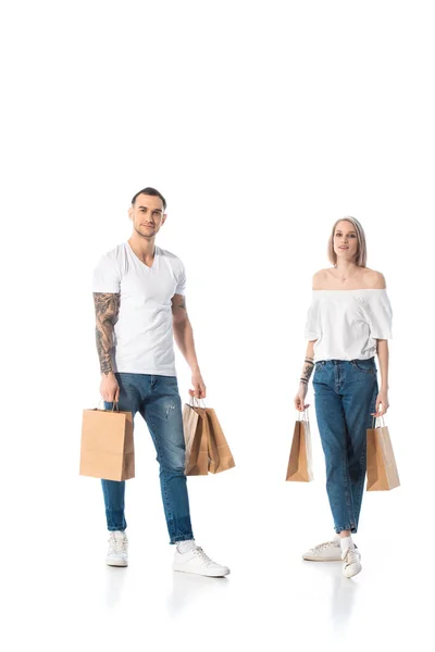 Jovem casal tatuado com sacos de compras isolados em branco — Fotografia de Stock