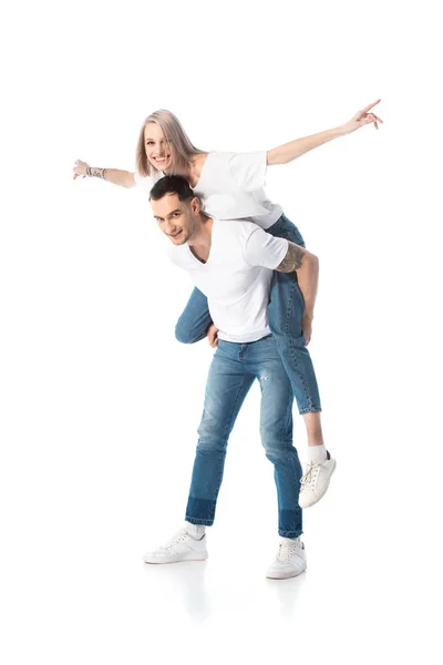 Happy young tattooed couple piggybacking isolated on white — Stock Photo