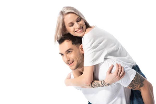 Happy young tattooed couple piggybacking isolated on white — Stock Photo