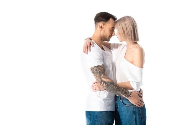 Sexy joven tatuado pareja abrazos aislado en blanco - foto de stock