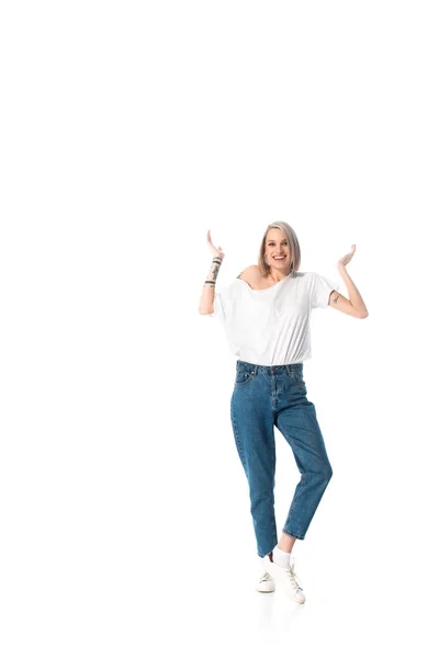 Feliz joven tatuado chica mostrando encogimiento gesto aislado en blanco - foto de stock