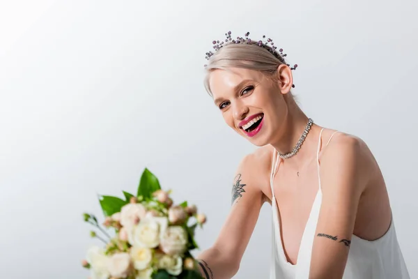 Foco seletivo de noiva tatuada bonita feliz com buquê floral no branco — Fotografia de Stock