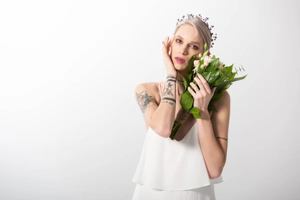 Portrait of beautiful tattooed bride posing with floral bouquet on white — Stock Photo