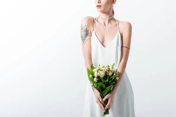 Cropped view of beautiful tattooed bride with floral bouquet on white — Stock Photo