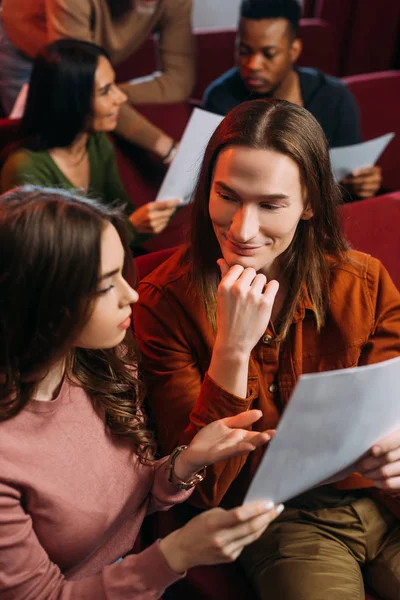 Actor y actriz escenario de lectura en asientos con otros - foto de stock