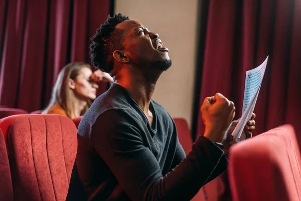 Afroamericano triste actor gritando y ensayando en el teatro con joven actor - foto de stock
