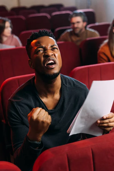 Emotional african american actor with screenplay in theatre — Stock Photo