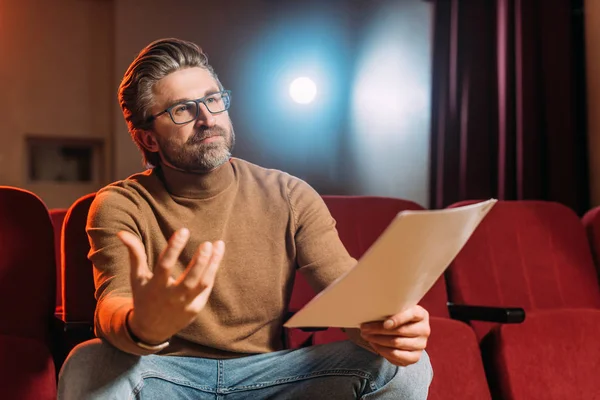 Emotional stage director with scenario on seats in theater — Stock Photo