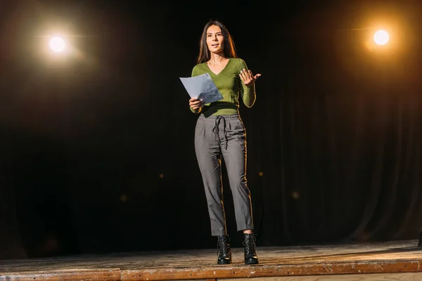 Jovem atriz atraente lendo cenário no palco no teatro — Fotografia de Stock