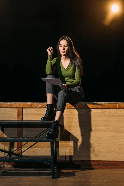 Schöne junge Schauspielerin liest Szenario auf der Bühne im Theater — Stockfoto
