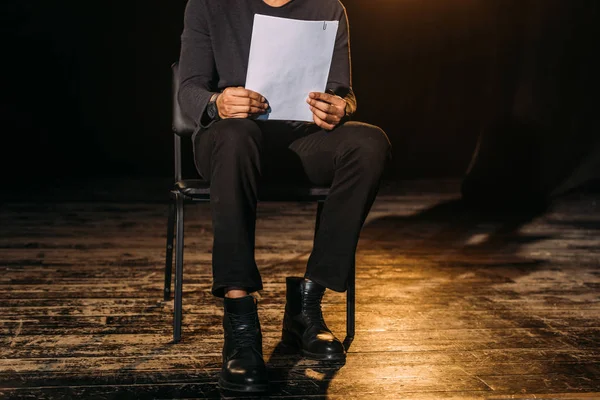 Cropped view of african american actor holding scenario on stage during rehearse — Stock Photo