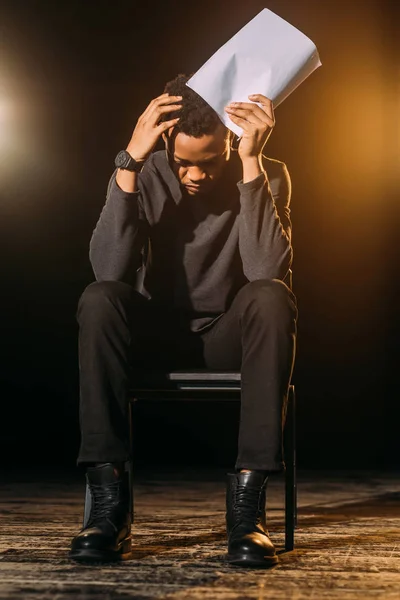 Emotional african american actor holding scenario on stage during rehearse — Stock Photo