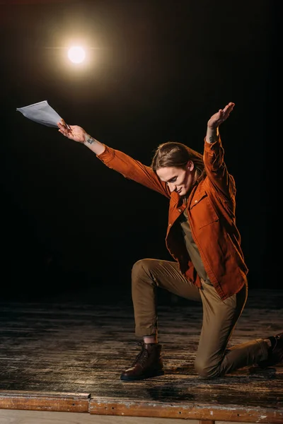 Handsome actor with scenario playing on stage during rehearse — Stock Photo