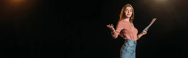 Panoramic shot of attractive young actress with scenario on black — Stock Photo