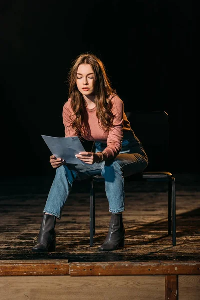 Bella giovane attrice che legge sceneggiatura sul palco in teatro — Foto stock