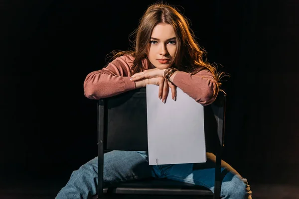 Attrayant jeune actrice avec scénario assis sur une chaise sur scène dans le théâtre — Photo de stock