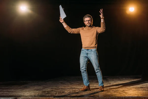 Emotionaler Theaterregisseur hält Szenario und steht während der Probe auf der Bühne — Stockfoto