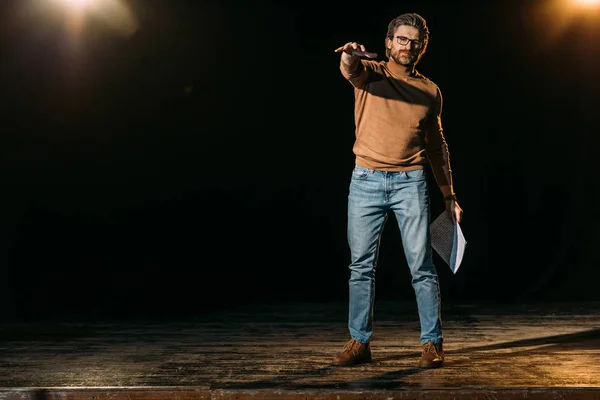 Metteur en scène émotionnelle tenant scénario et debout sur scène pendant la répétition dans le théâtre — Photo de stock