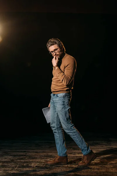 Thoughtful mature actor holding scenario and standing on stage during rehearse — Stock Photo