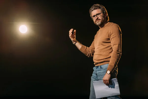 Handsome mature actor holding scenario and standing on stage during rehearse — Stock Photo