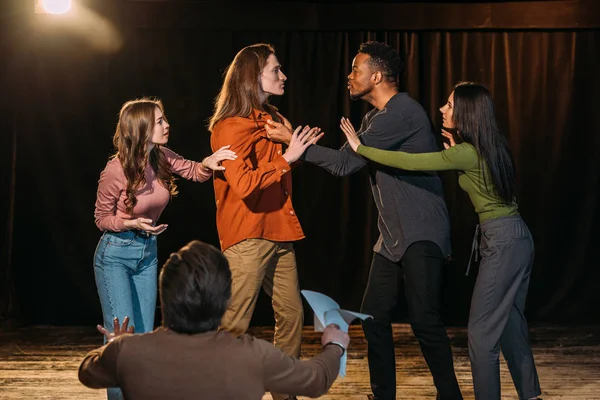Atores multiculturais e atrizes ensaiando luta no palco no teatro — Fotografia de Stock