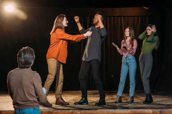 Atores multiétnicos ensaiando luta no palco no teatro — Fotografia de Stock