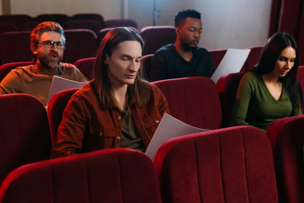 Actores multiétnicos y actriz leyendo guiones en el teatro - foto de stock