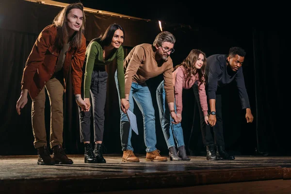 Glückliche Schauspieler und Schauspielerinnen verneigen sich auf der Bühne — Stockfoto