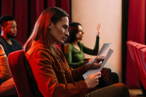 Actores jóvenes multiculturales y actriz leyendo guiones en el teatro - foto de stock