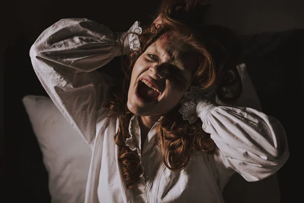 Демоническая девушка в ночной рубашке кричит в спальне — стоковое фото