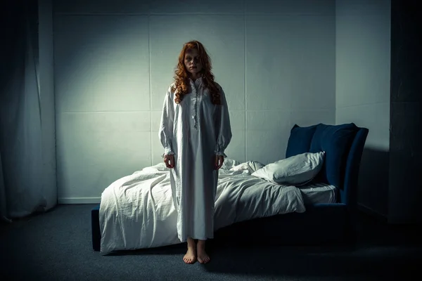 Inquietante demoniaca ragazza in camicia da notte in piedi in camera da letto — Foto stock