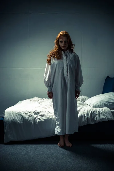 Female demon in nightgown standing in bedroom — Stock Photo