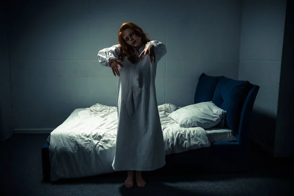 Жуткая женщина-демон в ночной рубашке, стоящая в спальне — стоковое фото