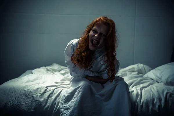 Obsesionada chica espeluznante en camisón gritando en el dormitorio - foto de stock