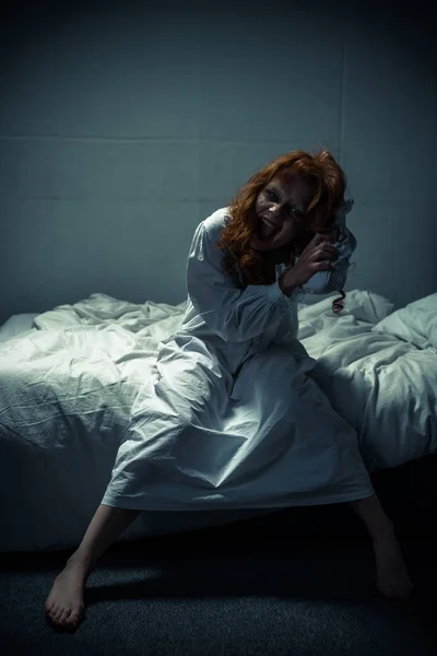 Demonio femenino en camisón gritando en el dormitorio - foto de stock