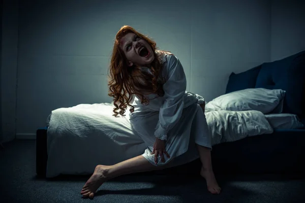 Demonic creepy girl in nightgown shouting in bedroom — Stock Photo