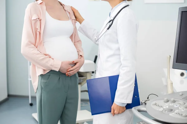 Vista ritagliata della donna incinta dopo aver consultato il medico in clinica ginecologica — Foto stock