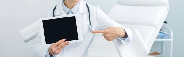 Panoramaaufnahme eines Gynäkologen, der auf ein digitales Tablet mit leerem Bildschirm in der Klinik zeigt — Stockfoto