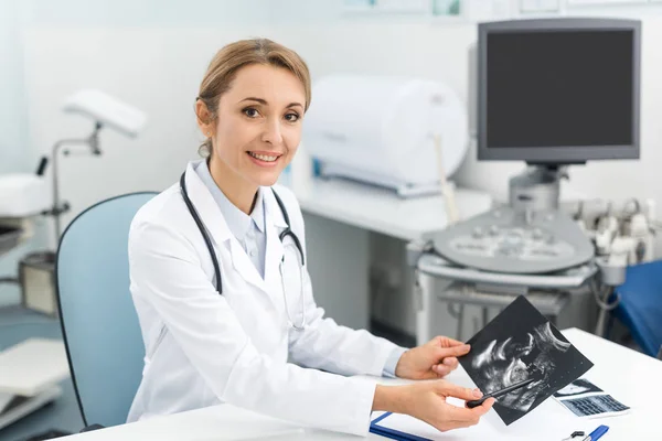 Professional female doctor showing ultrasound scan in clinic — Stock Photo