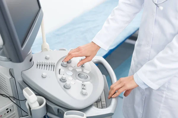 Обрезанный вид врача, работающего с ультразвуковым сканером с чистым экраном в клинике — стоковое фото