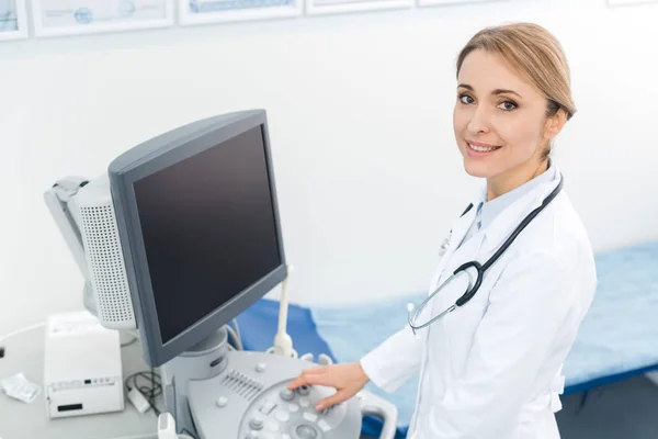 Hermoso médico profesional que trabaja con escáner de ultrasonido con pantalla en blanco - foto de stock