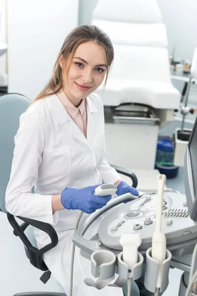 Jovem médico sorrindo trabalhando com scanner de ultra-som na clínica — Fotografia de Stock