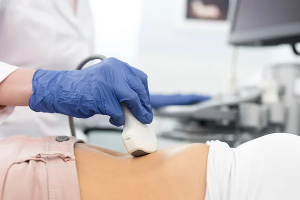 Vista ritagliata del medico che esamina lo stomaco del paziente con ecografia — Foto stock