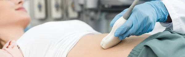 Vista recortada del médico examinando el estómago del paciente con ecografía, inyección panorámica - foto de stock